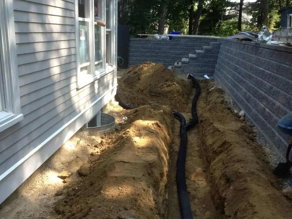 Exterior French drain installation along foundation