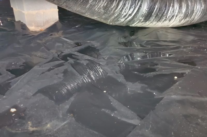 Efflorescence and water stains along the base of a basement wall