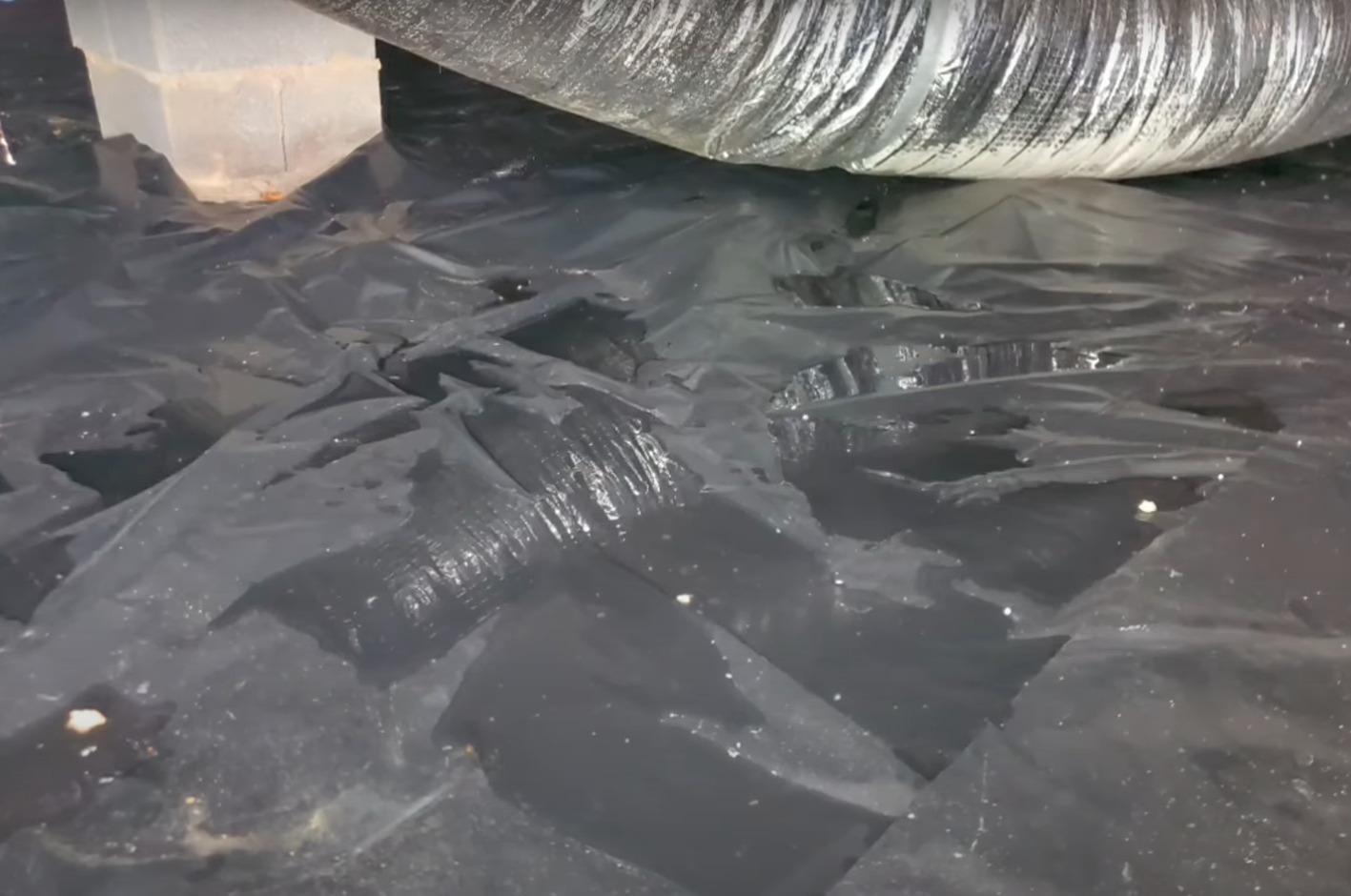 Efflorescence and water stains along the base of a basement wall